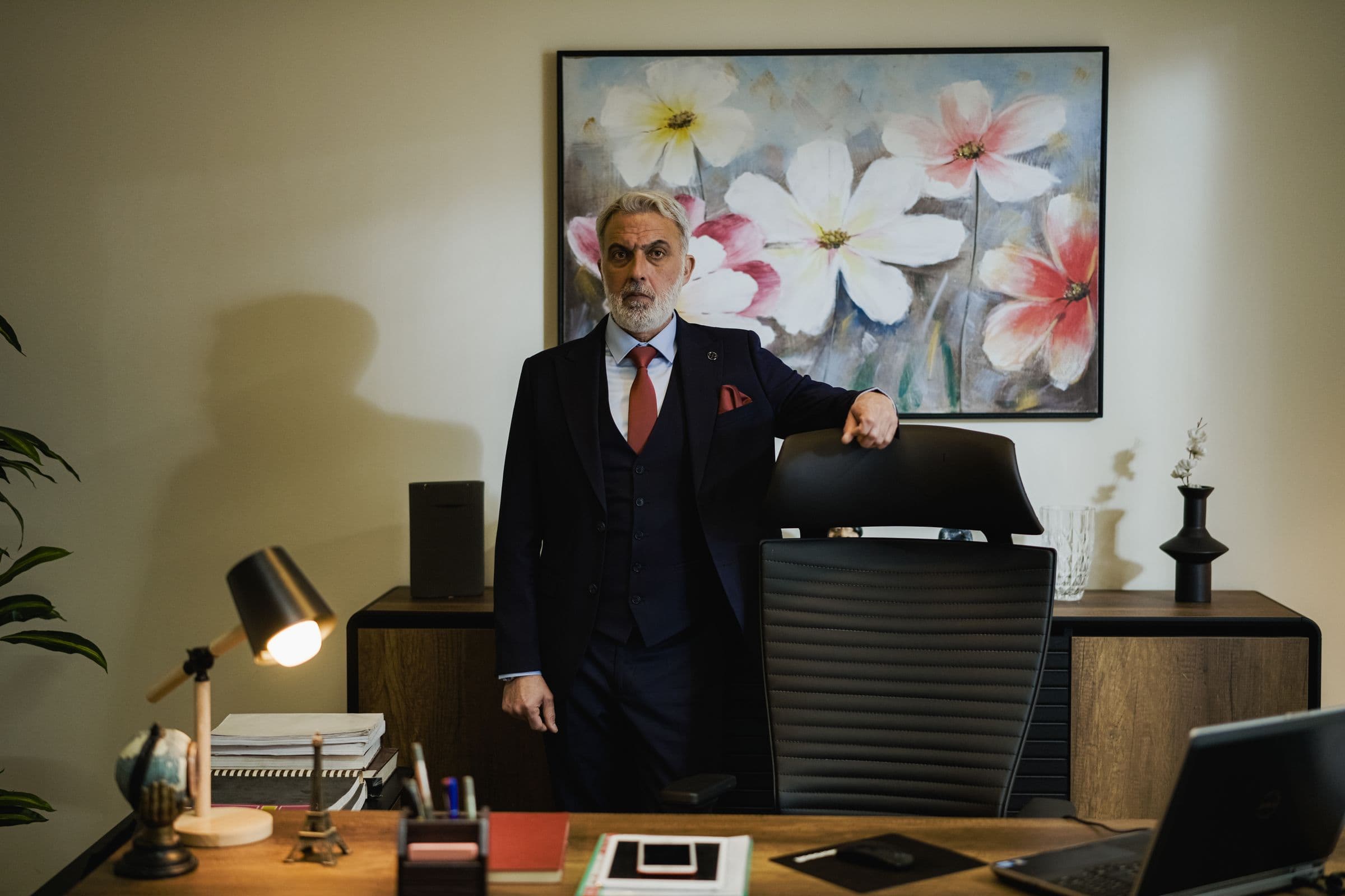 A distinguished business executive standing confidently in his office